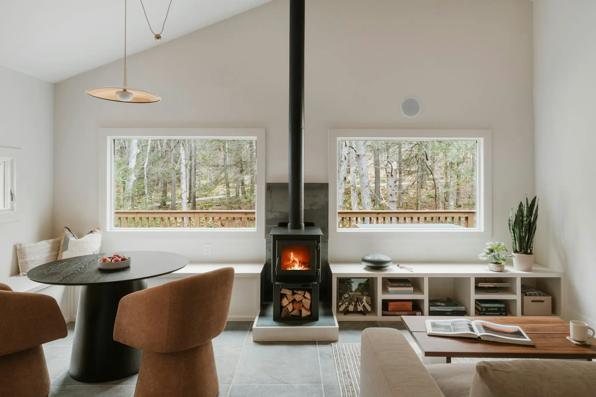 A bright, finished living room with a wood stove and large windows